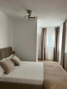 a bedroom with a bed with a ceiling fan at Vila San Nicoara in Curtea de Argeş +29 photos