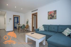 a living room with a blue couch and a table at Patacona Resort Apartments Primera Linea in Valencia