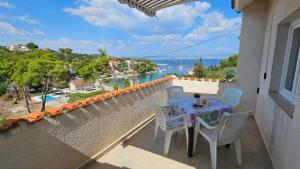 a table and chairs on a balcony with a view of the water at Apartments Šolta in Rogač