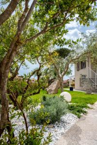 einen Garten mit Felsen und Bäumen vor einem Haus in der Unterkunft La Botte e il Vino Rooms in Capoterra