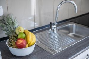 a bowl of fruit on a counter next to a sink at Apartments Šolta in Rogač +67 photos