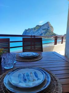 Una mesa de madera con dos platos con pájaros encima. en Apartamento Dúplex Aloha Calpe, primera línea de playa, en Calpe