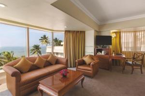 a living room with a couch and a television at Ramada Plaza By Wyndham Palm Grove in Mumbai