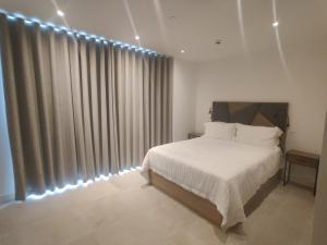 a bedroom with a white bed and a large window at Gibraltar Self-catering Studio Accommodation in Gibraltar +18 photos