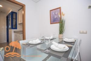 a dining room with a glass table with wine glasses at Patacona Resort Apartments Primera Linea in Valencia