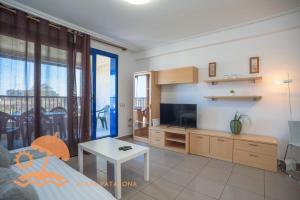 a living room with a tv and a table at Patacona Resort Apartments Primera Linea in Valencia