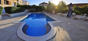 Una piscina con agua azul en un patio. en Cosy suite with garden terrace, en Trogir