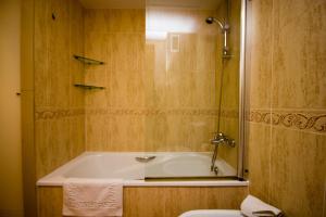 a bathroom with a bath tub and a toilet at Patacona Resort Apartments Primera Linea in Valencia