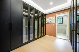 KoolewongにあるPrime Ocean Villa Floor-Ceiling & Sunrise Terraceのガラスのキャビネットと廊下がある空の部屋