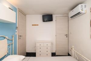 a bedroom with a bed and a tv on the wall at Affittacamere - L'ancora in Stintino