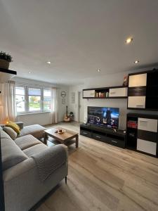 a living room with a couch and a tv at Burgblick am Malerweg in Hohnstein