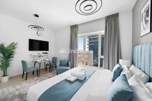a bedroom with a bed and a table and chairs at Luxury Unit Located in Icon Tower, JLT in Dubai