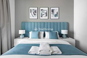 a bedroom with a blue and white bed with two lamps at Luxury Unit Located in Icon Tower, JLT in Dubai