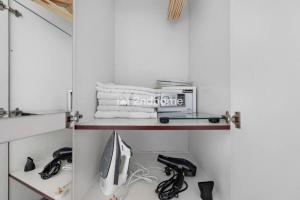 a room with a shelf with a computer and other items at Luxury Unit Located in Icon Tower, JLT in Dubai