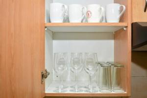 a cabinet with four wine glasses in it at Oasis Home in Midrand