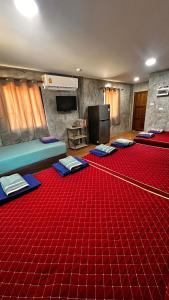 a room with a red carpet and a room with a tv at NADOHN-Homestay in Ban Nam Lai Ta Tum