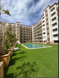 an apartment building with a large yard with a swimming pool at Luxury haven with pool in Agadir