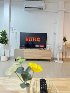 a living room with a television with the netflix sign on it at Supasarn House in Hat Yai +39 photos