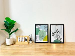 three picture frames sitting on a shelf with a plant at Supasarn House in Hat Yai