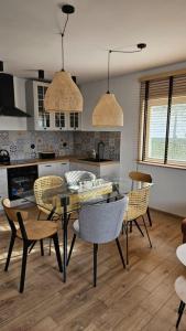 a kitchen and dining room with a table and chairs at Dom letniskowy do wynajęcia z własną Przystanią nad rzeką Narew - linia brzegowa in Dzbenin