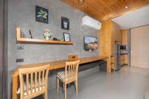 a kitchen with a wooden table and chairs at Relife Apartments by Tropiclook - Fast WiFi , Pool and Gym in Phuket