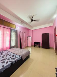 グワーハーティーにあるDreamy Den Homestayのピンクの壁のベッドルーム1室(ベッド1台付)