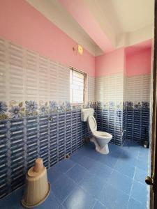グワーハーティーにあるDreamy Den Homestayのピンクの壁のバスルーム(トイレ付)