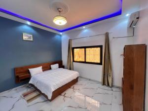 a bedroom with a bed and a blue ceiling at Résidence Khadija, Aéroport 15mn AIBD, CICAD hôtel in Rufisque