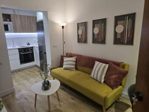 a living room with a green couch and a table at Apartamento Teror Encantado in Teror +14 photos