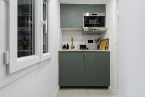 Huchette - Appartement chaleureux Paris في باريس: مطبخ مع حوض وميكروويف