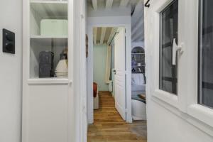 Huchette - Appartement chaleureux Paris في باريس: ممر بأبواب بيضاء وغرفة نوم +7 صور