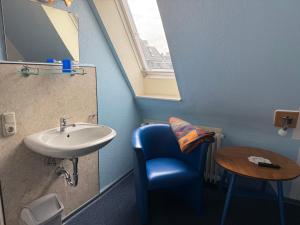 a bathroom with a blue chair and a sink at Haus Meereswoge, Duhnen in Cuxhaven +65 photos
