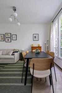 a living room with a black table and chairs at Guersant - Maison cosy 6PAX proche Etoile in Paris