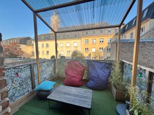 balkon z kolorowymi poduszkami i drewnianym stołem w obiekcie Le Terrazza - 1P à 2P Terrasse - Henriville w Amiens