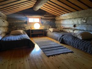 a room with two beds in a log cabin at Villa Havu in Kuusamo