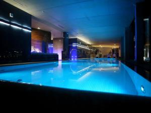 duży basen z niebieską wodą w budynku w obiekcie Przystań Hotel&Spa w Olsztynie