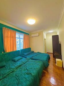 a bedroom with a large green bed and a window at Emerald Villa in Pasir Gudang +17 photos