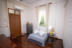 a bedroom with a bed and a table and a window at บ้านแสนรัก Casa Dolce Casa, Prakhon Chai in Prakhon Chai