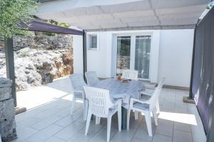 a dining room with a table and chairs on a patio at Apartments Šolta in Rogač