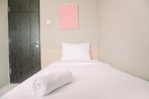 当格浪Comfort 2BR at 3rd Floor Baileys Apartment By Travelio的一张白色的床,上面有枕头