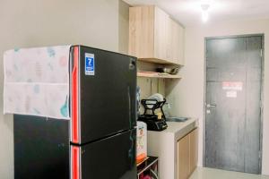 当格浪Comfort 2BR at 3rd Floor Baileys Apartment By Travelio的一间厨房,里面配有黑色冰箱