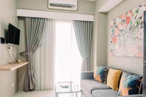 当格浪Comfort 2BR at 3rd Floor Baileys Apartment By Travelio的带沙发和大窗户的客厅