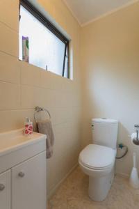 łazienka z białą toaletą i oknem w obiekcie Joe & Mary's Cosy homestay room w Auckland +11 zdjęć