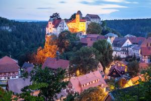 a town on a hill with houses and trees at Burgblick am Malerweg in Hohnstein