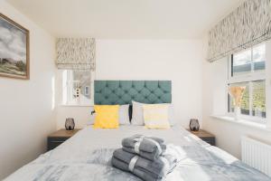 a bedroom with a bed with towels on it at Peak District New Modern Cottage with Mountain Views in Buxton