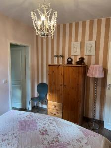 a bedroom with a bed and a dresser and a chandelier at Apartment Vis-a-vis in Wernigerode