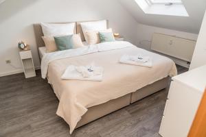 a bedroom with a large bed with towels on it at krönchen zwei in Siegen