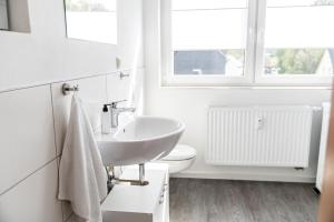 a white bathroom with a sink and a toilet at krönchen zwei in Siegen +12 photos