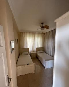 a bedroom with two beds and a ceiling fan at Villa with pool in Goldcity tourism complex in Kargicak