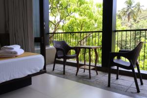 a bedroom with a table and chairs and a balcony at Handagedara Resort & Spa in Mirissa
